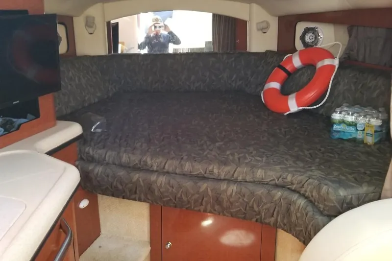 Slide: The Image of 2004 Sea Ray 300 Sundancer cabin interior with bed, life preserver, and bottled water. - 4