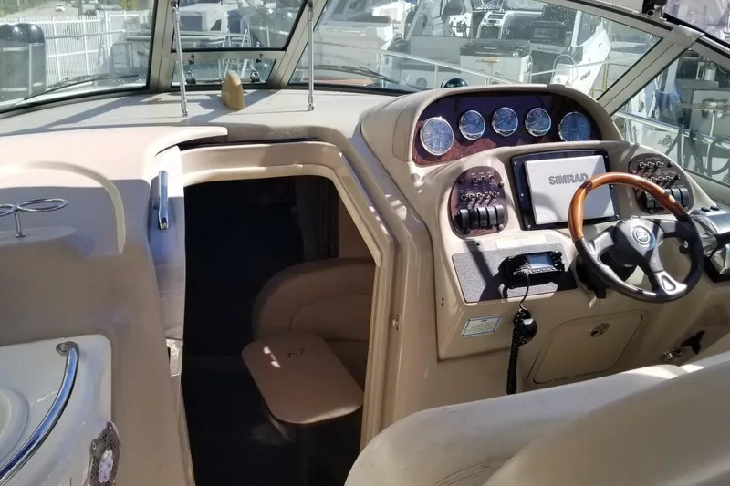 Slide: The Image of Interior view of 2004 Sea Ray 300 Sundancer boat cockpit with steering wheel and controls. - 5