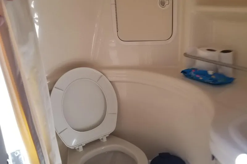 Slide: The Image of Compact bathroom in 2004 Sea Ray 300 Sundancer boat with toilet and toiletries. - 6