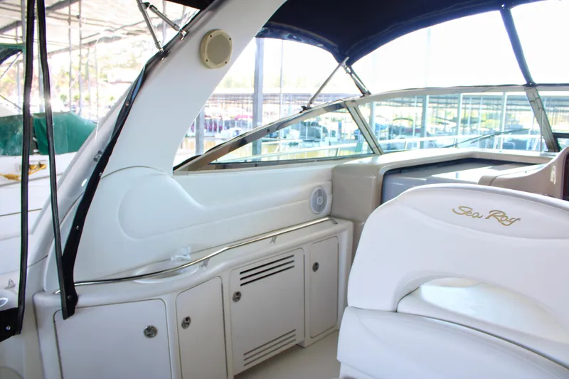 Slide: The Image of Interior view of a 2003 Sea Ray 380 Sundancer yacht, showcasing seating and dashboard. - 24