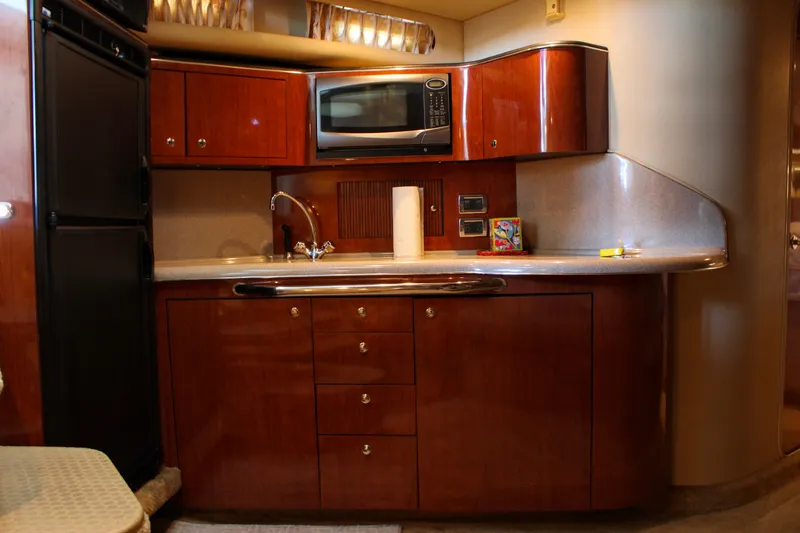 Slide: The Image of Luxurious 2003 Sea Ray 380 Sundancer yacht kitchen with wood cabinetry and modern appliances. - 25