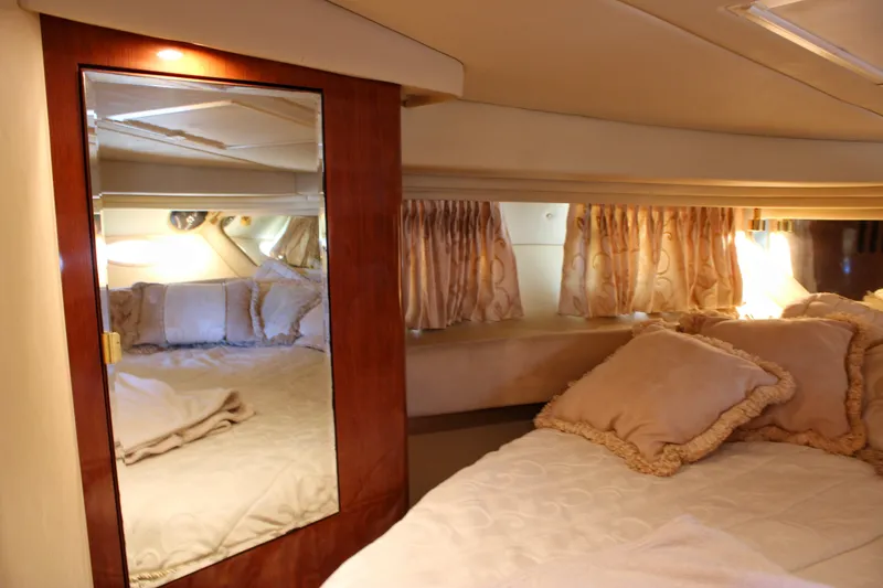 Slide: The Image of Luxurious cabin interior of 2003 Sea Ray 380 Sundancer with elegant bedding and mirrored closet. - 26