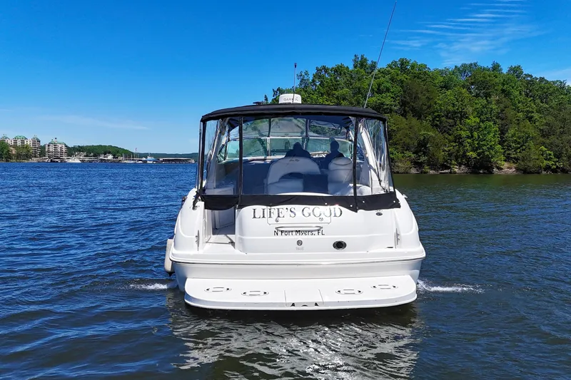 Slide: The Image of 2003 Sea Ray 380 Sundancer cruising on a scenic lake with lush green shoreline. - 3