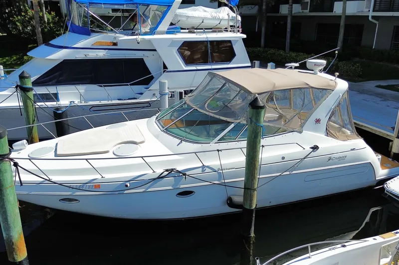 The Image of 2002 Cruisers Yachts 3572 Express docked at marina, featuring sleek design and beige canopy. - 0