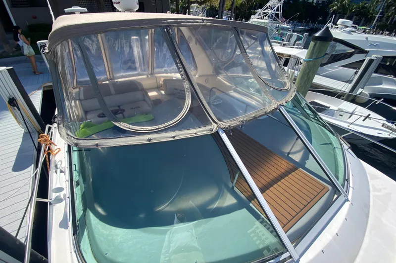 Slide: The Image of 2002 Cruisers Yachts 3572 Express docked, featuring a covered cockpit and sleek design. - 14