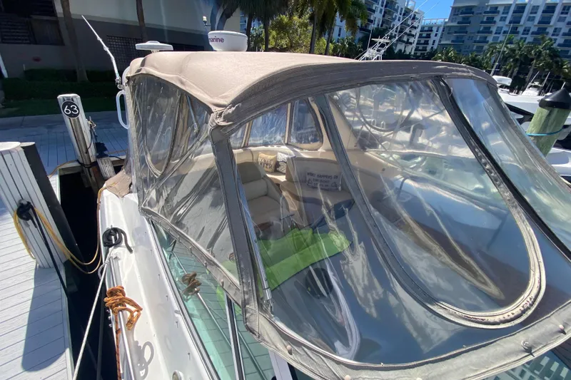 Slide: The Image of 2002 Cruisers Yachts 3572 Express docked with clear canopy and marina view. - 18