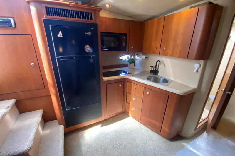 Slide: The Image of Luxurious 2002 Cruisers Yachts 3572 Express kitchen with wood cabinetry and modern appliances. - 27