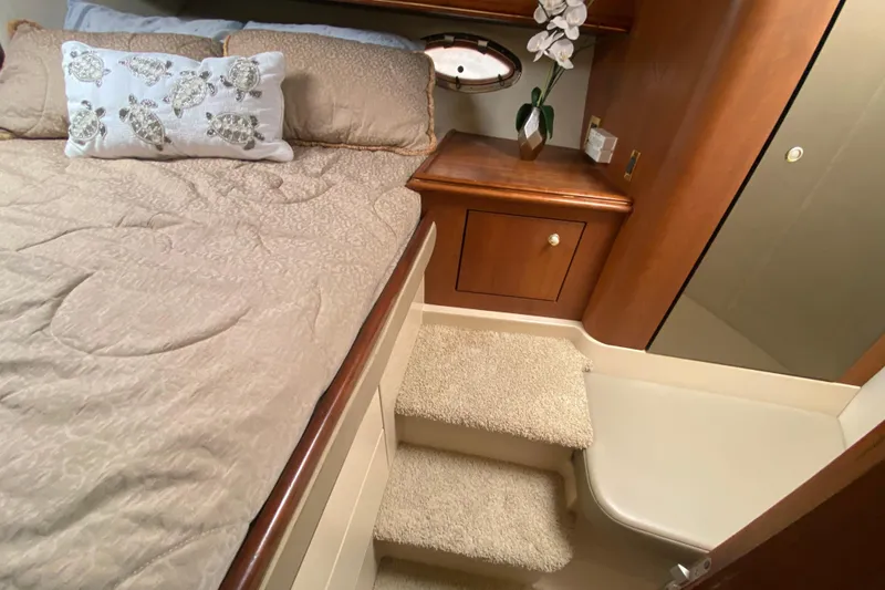 Slide: The Image of Luxurious cabin interior of 2002 Cruisers Yachts 3572 Express with plush bedding and wooden cabinetry. - 31