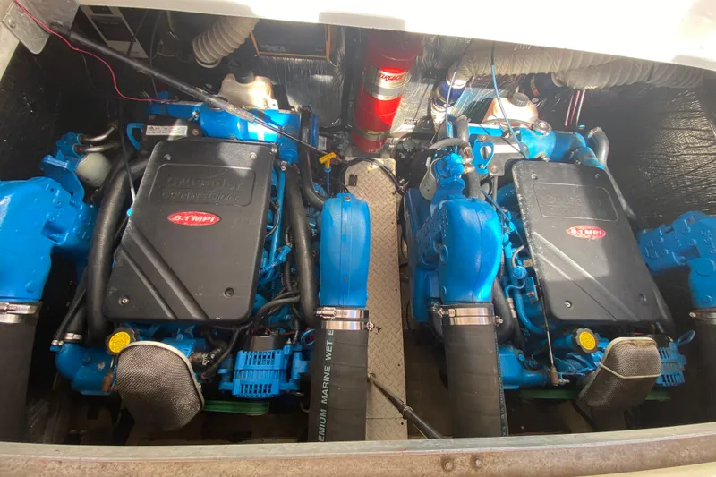 Slide: The Image of Engine compartment of a 2002 Cruisers Yachts 3572 Express, featuring twin blue marine engines. - 34