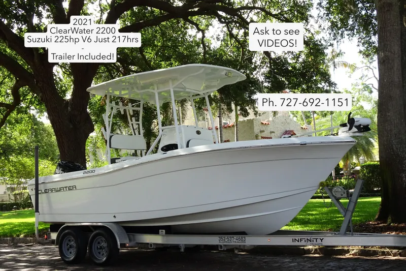 The Image of 2021 Clearwater 2200 Center Console boat on trailer, parked outdoors under trees. - 0