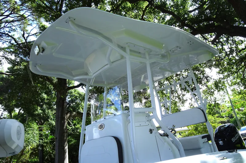 Slide: The Image of 2021 Clearwater 2200 Center Console boat under trees, showcasing sleek design and structure. - 17