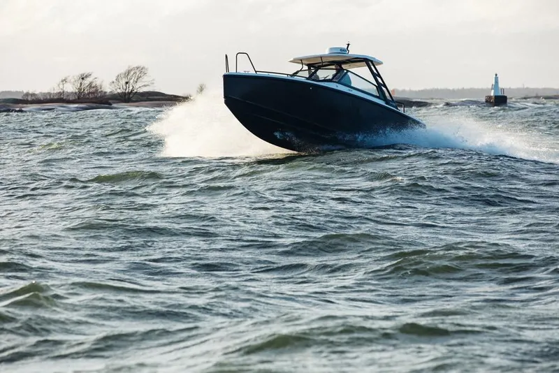 Slide: The Image of 2027 XO DSCVR 9 T-TOP boat navigating choppy waters with dynamic motion. - 3
