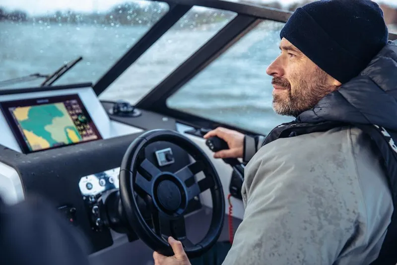Slide: The Image of Man steering 2027 XO DSCVR 9 T-TOP boat, using navigation system on water. - 6
