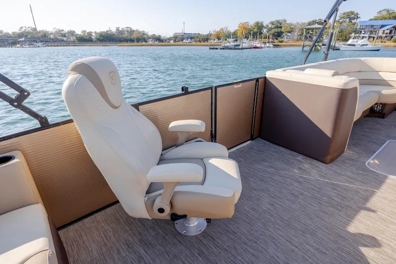Slide: The Image of Luxury seating on 2022 Godfrey Monaco 255 SFL pontoon boat, docked by scenic waterfront. - 15