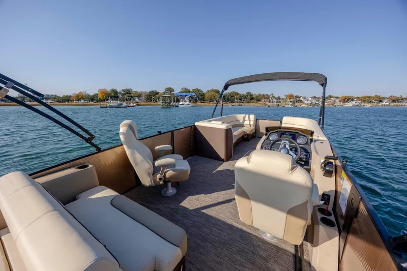 Slide: The Image of 2022 Godfrey Monaco 255 SFL pontoon boat on calm water, featuring spacious seating and helm. - 19