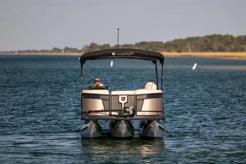 Slide: The Image of 2022 Godfrey Monaco 255 SFL pontoon boat on a serene lake. - 5