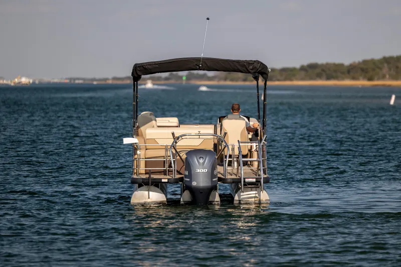 Slide: The Image of 2022 Godfrey Monaco 255 SFL pontoon boat cruising on a calm lake. - 8