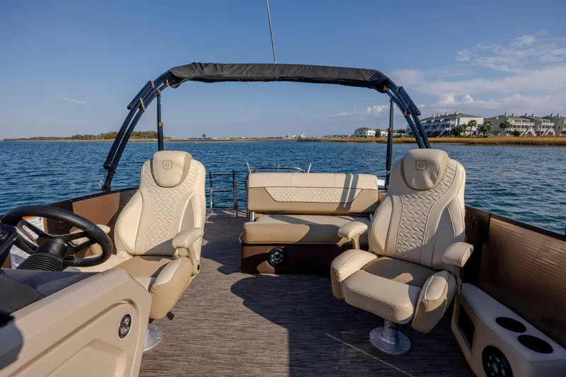 Slide: The Image of Luxurious 2022 Godfrey Monaco 255 SFL pontoon boat interior with plush seating on a sunny day. - 9