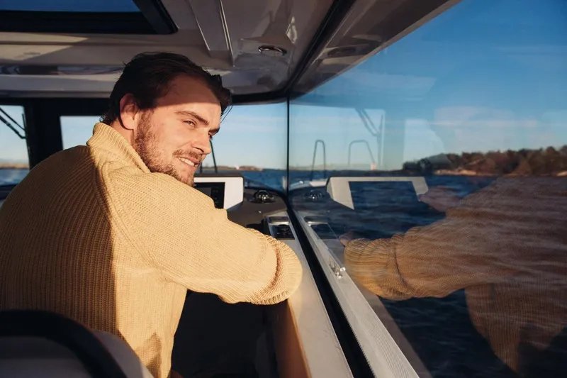 Slide: The Image of Man enjoying a ride on a 2027 XO EXPLR 9 boat, scenic ocean view. - 12