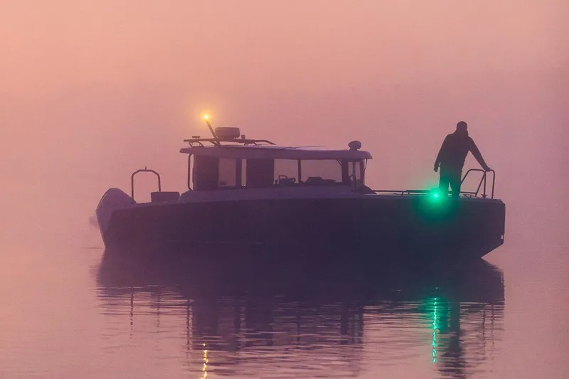 Slide: The Image of A silhouette of the 2027 XO EXPLR 9 boat in misty waters at sunset. - 3