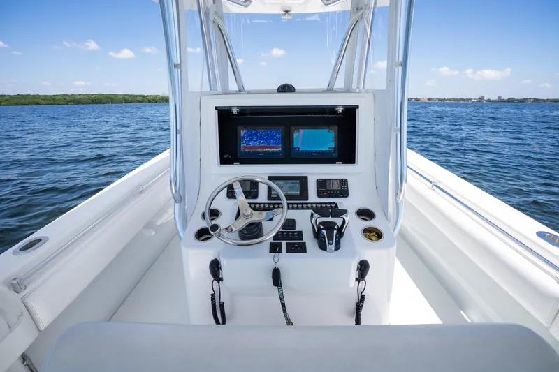 Slide: The Image of 2022 Contender 35 ST boat cockpit with dual screens and steering wheel on open water. - 17