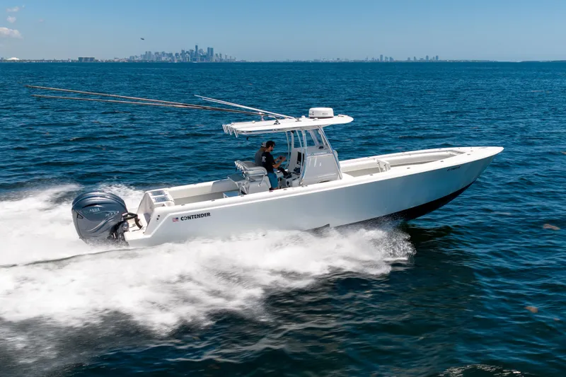 Slide: The Image of 2022 Contender 35 ST boat cruising on open water with city skyline in background. - 2