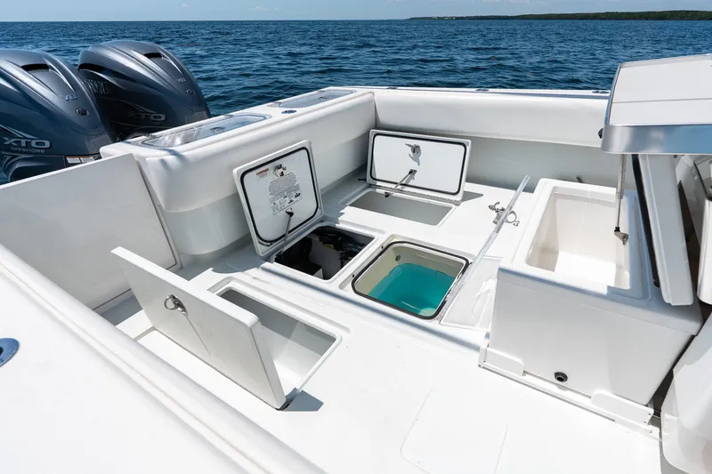 Slide: The Image of 2022 Contender 35 ST boat deck with open storage compartments and dual engines. - 30