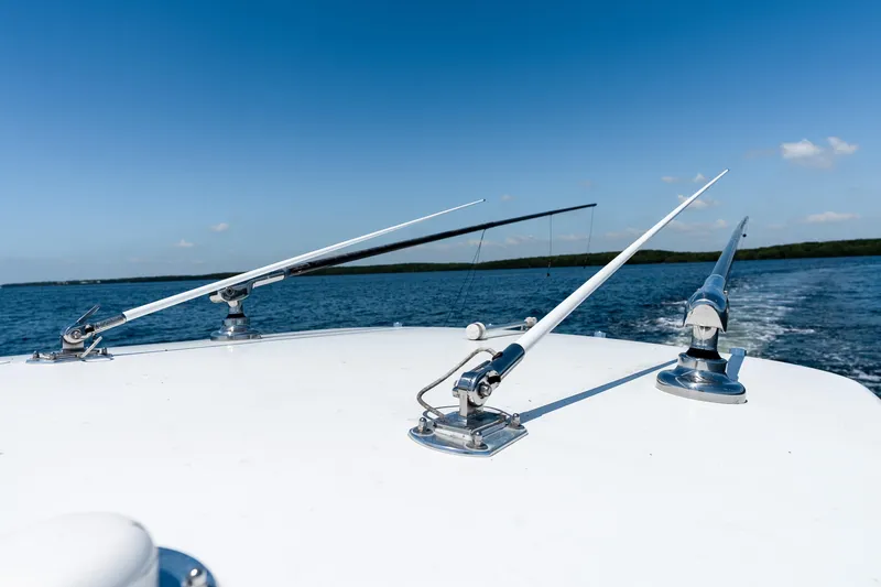 Slide: The Image of 2022 Contender 35 ST boat with fishing outriggers on open water under clear blue sky. - 45