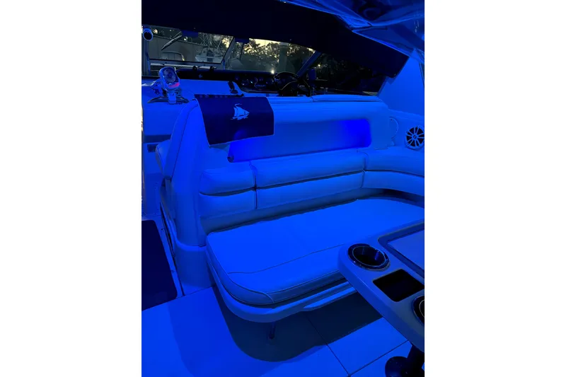 Slide: The Image of Interior of 1994 Sea Ray 300 Sundancer with blue ambient lighting and seating area. - 12