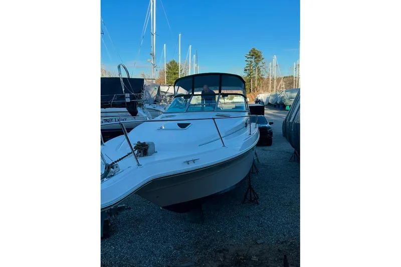 Slide: The Image of 1994 Sea Ray 300 Sundancer boat on stands in a marina, clear blue sky. - 14