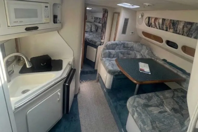 Slide: The Image of Interior of a 1994 Sea Ray 300 Sundancer boat with kitchenette and seating area. - 3