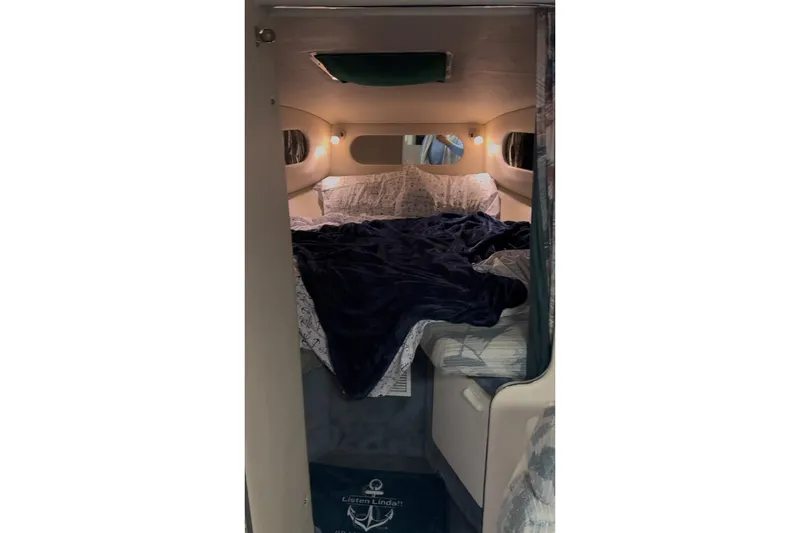 Slide: The Image of 1994 Sea Ray 300 Sundancer cabin interior with cozy bed and ambient lighting. - 4