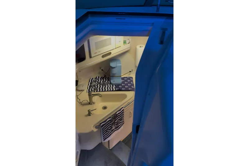 Slide: The Image of Interior of 1994 Sea Ray 300 Sundancer boat with kitchenette and blue lighting. - 5