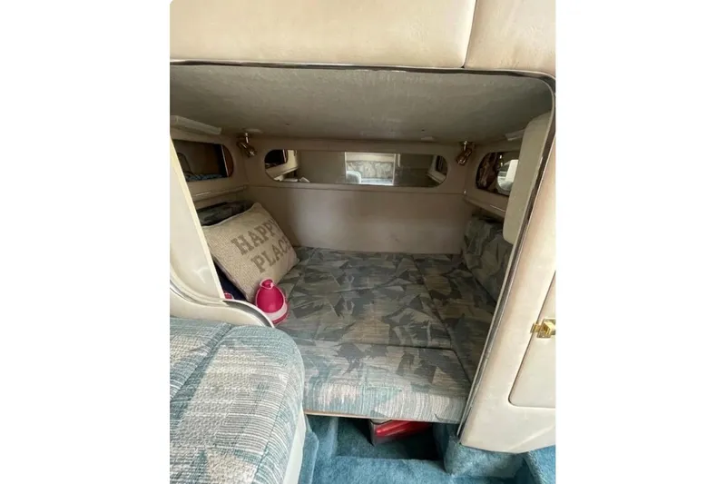 Slide: The Image of Interior cabin of 1994 Sea Ray 300 Sundancer with cozy seating and "Happy Place" pillow. - 7