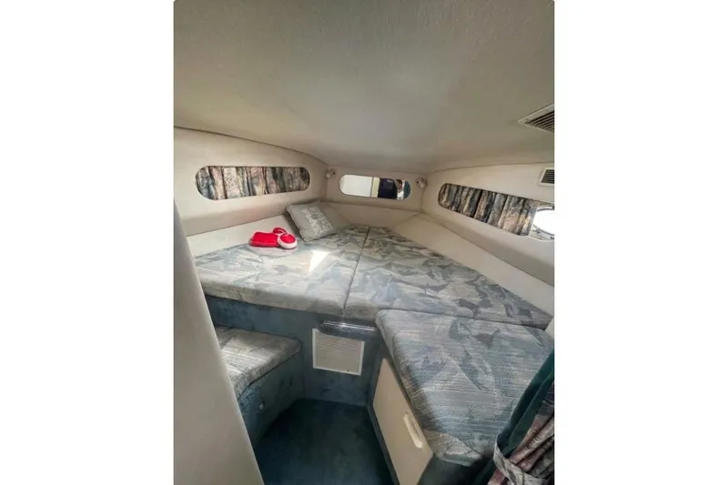 Slide: The Image of 1994 Sea Ray 300 Sundancer cabin interior with bed and patterned upholstery. - 8