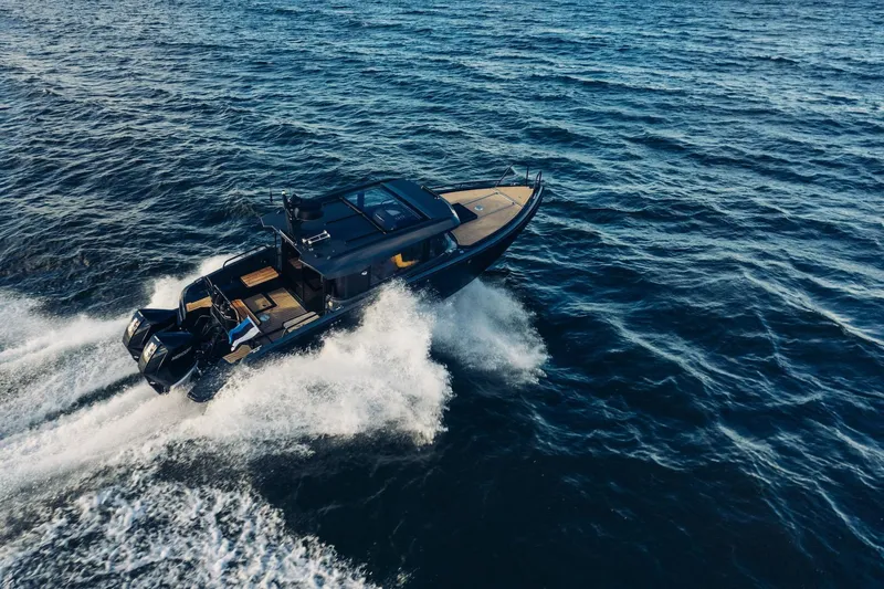Slide: The Image of 2027 XO EXPLR 10 Sport Plus boat cruising on open water. - 4