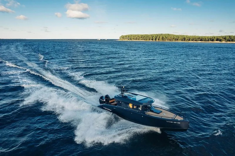 Slide: The Image of 2027 XO EXPLR 10 Sport Plus cruising on open water under a clear sky. - 5