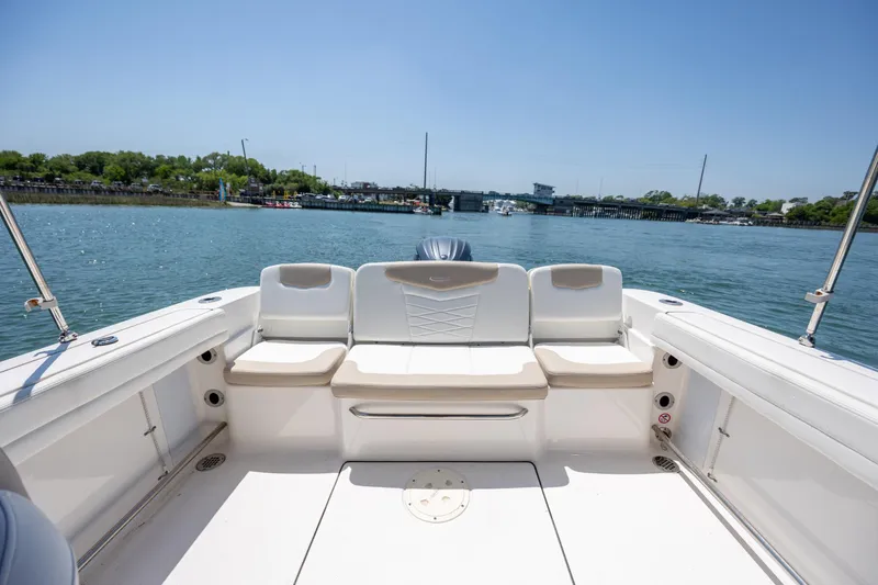 Slide: The Image of 2024 Robalo R207 Dual Console boat interior with seating, on a sunny day by the water. - 18