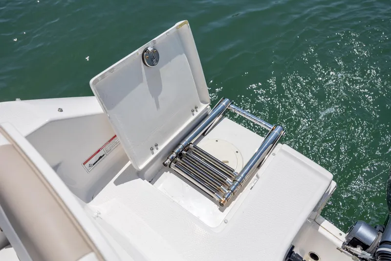 Slide: The Image of 2024 Robalo R207 Dual Console boat with a folded swim ladder on deck. - 19
