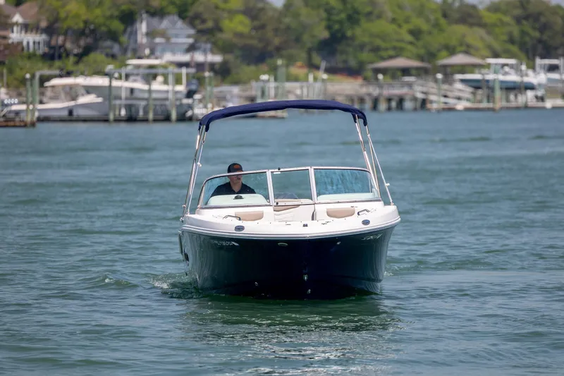Slide: The Image of 2024 Robalo R207 Dual Console boat cruising on a scenic waterway. - 4