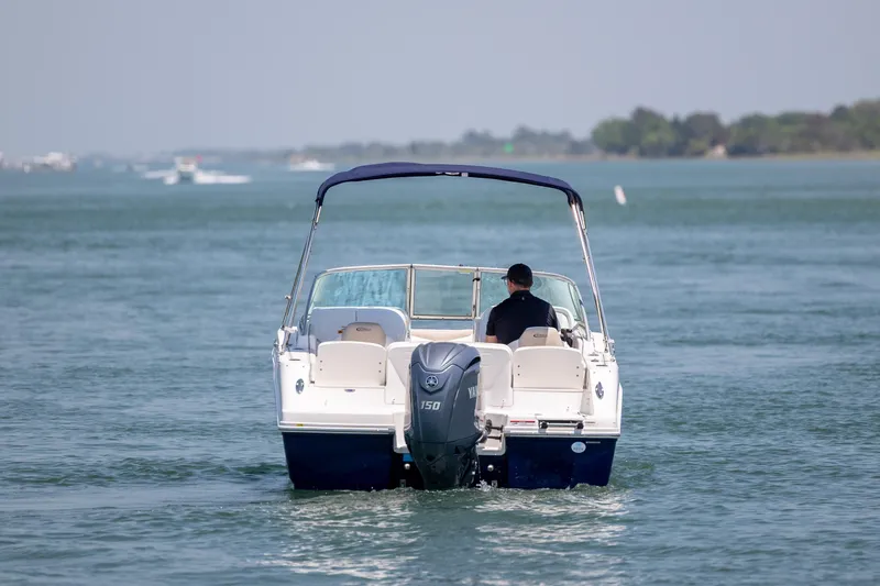 Slide: The Image of 2024 Robalo R207 Dual Console boat cruising on a calm lake. - 7