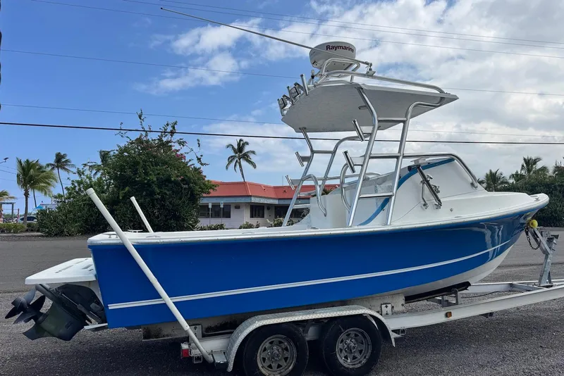 Slide: The Image of 2008 Force Marine Force 21 boat on trailer, blue and white, parked outdoors. - 3