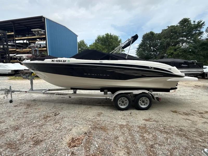 The Image of 2009 Bayliner 225 BR boat parked on trailer outdoors. - 1