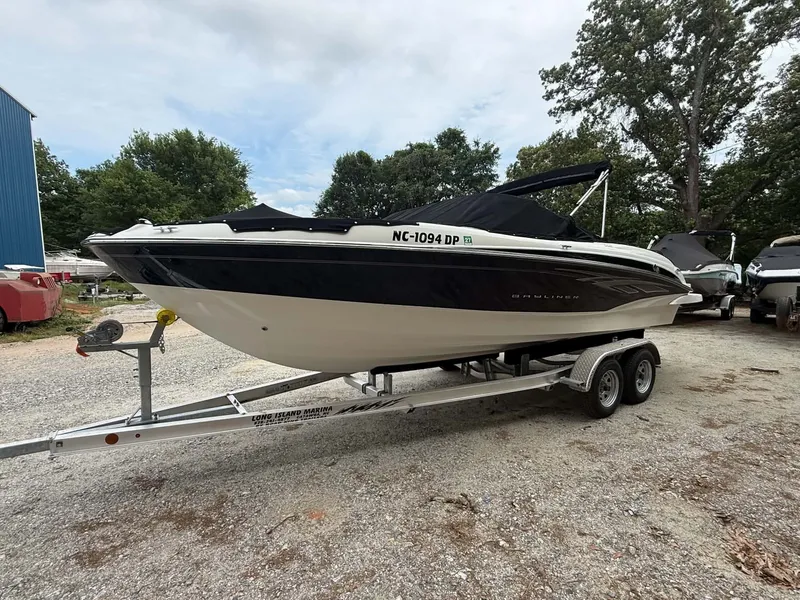 Slide: The Image of 2009 Bayliner 225 BR boat parked on trailer outdoors. - 13