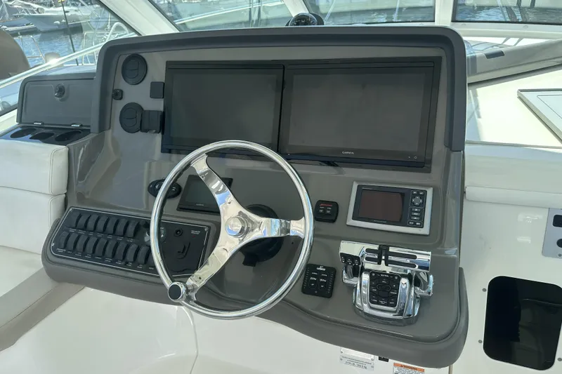Slide: The Image of 2009 Boston Whaler 345 Conquest helm with dual screens and steering wheel. - 11