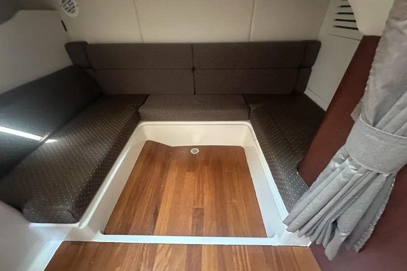 Slide: The Image of 2009 Boston Whaler 345 Conquest cabin interior with wood flooring and cushioned seating. - 12