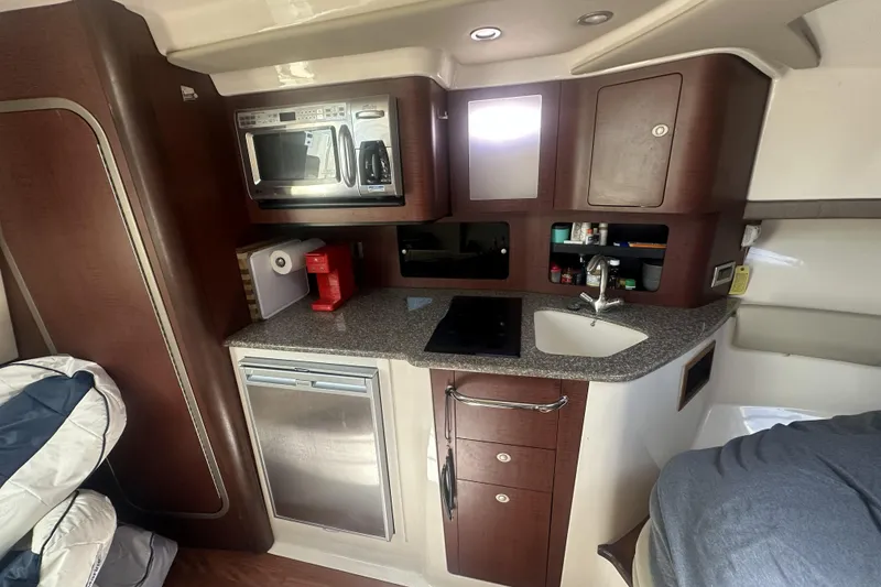Slide: The Image of 2009 Boston Whaler 345 Conquest cabin kitchen with microwave, sink, and storage. - 15
