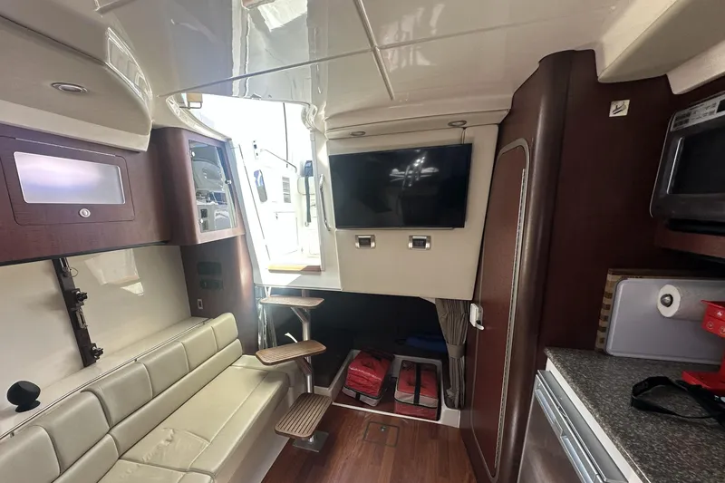 Slide: The Image of Interior of 2009 Boston Whaler 345 Conquest with seating, TV, and kitchenette. - 17