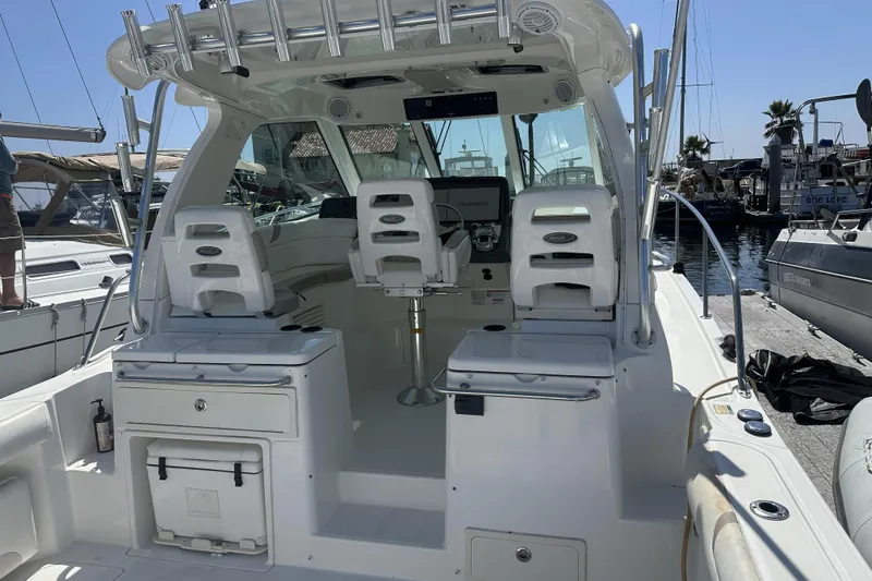 Slide: The Image of 2009 Boston Whaler 345 Conquest boat interior with helm and seating at marina. - 8