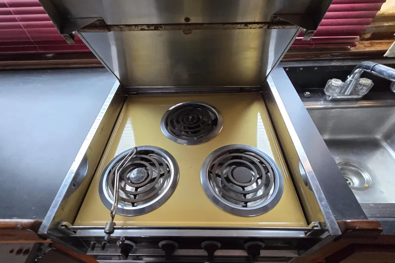 Slide: The Image of Vintage stove in a 1975 Hatteras 46 Convertible yacht kitchen, next to a stainless steel sink. - 11